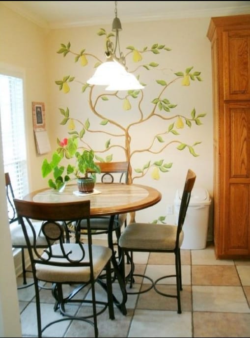 Before photo of a breakfast nook with older wall color, pendant light, table, and surrounding trim