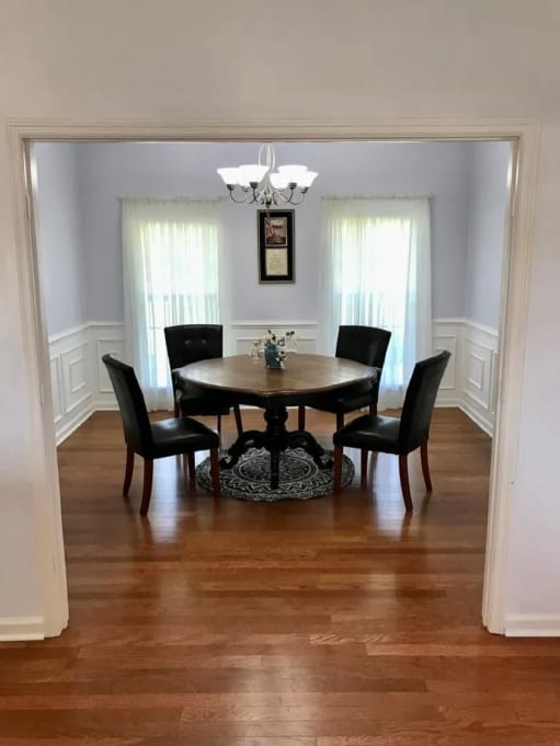 After photo of a bright dining room wall finish with table, curtains, trim, and updated paint color